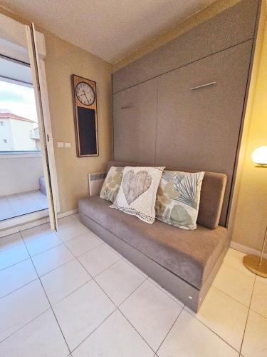 - un canapé dans une chambre avec une horloge murale dans l'établissement Plages,Palais des Festivals,Port,Zone piétonne,Suquet, à Cannes