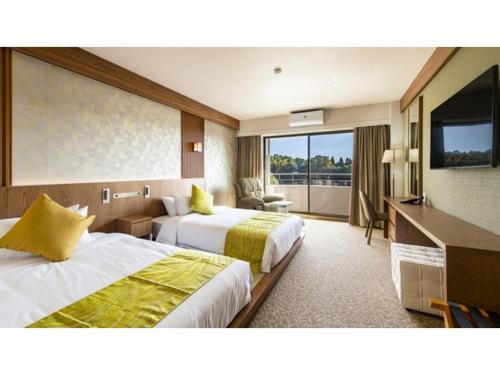 una camera d'albergo con due letti e una televisione di UE GARDEN RESORT - Vacation STAY 41432v a Tōgane