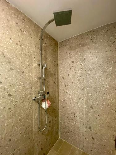 a shower with a shower head in a bathroom at Beach condo in Tijuana