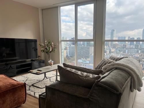 a living room with a couch and a large window at Luxury apartment in the city center in Rotterdam