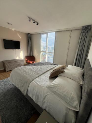 a bedroom with a large bed with a large window at Luxury apartment in the city center in Rotterdam