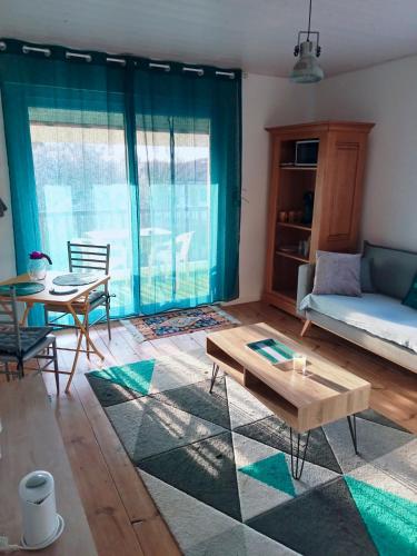 un salon avec un canapé et une table dans l'établissement Chambre d'hôte avec salle de bain cosy au coeur du marais de Longeville-sur-mer, à Longeville-sur-Mer