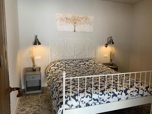 a bedroom with a white bed with a black and white bedspread at Venta Cerro del Águila in Ventas con Peña Aguilera