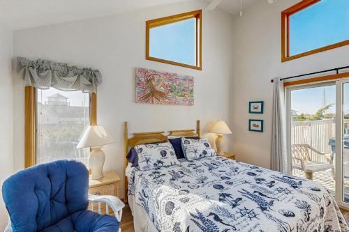 a bedroom with a bed and a chair and a window at Feelin' Nauti 866 in Waves