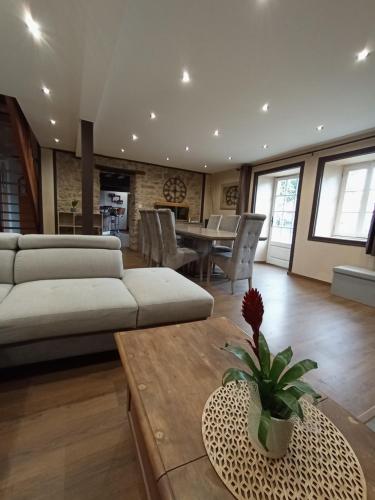 un salon avec un canapé et une table dans l'établissement L'orée du bois, à Saint-Étienne-du-Bois