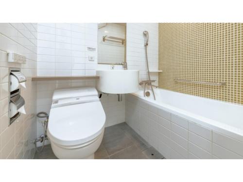 a bathroom with a toilet and a bath tub at The OneFive Sendai - Vacation STAY 45011v in Sendai