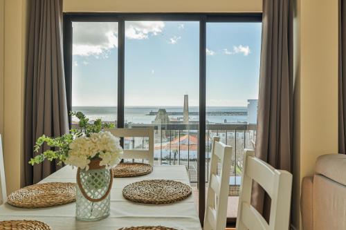 a dining table with a view of the ocean at House at the Sea (city historial center with sea view) in Ponta Delgada