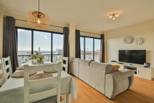 a living room with a couch and a television at House at the Sea (city historial center with sea view) in Ponta Delgada