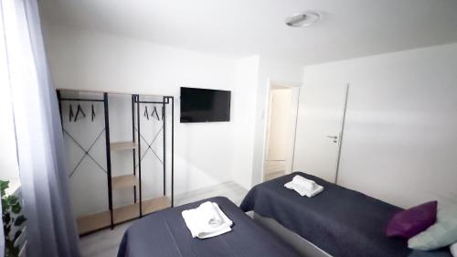 a room with two beds and a tv in it at 2 ZKB-3OG oder 3 ZKB-UG im Zentrum zw Rathaus und Dom in Augsburg