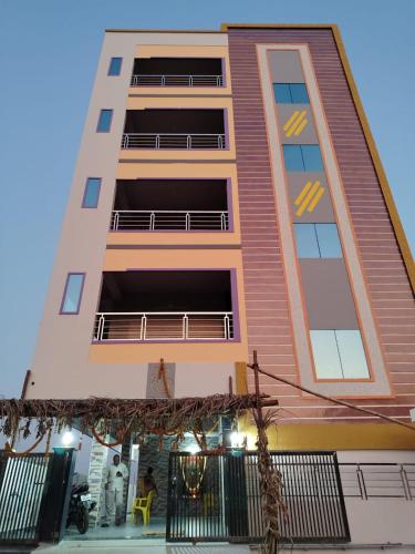 ティルパティにあるAJ srinivasa HOMESTAYの時計が付いている高い建物