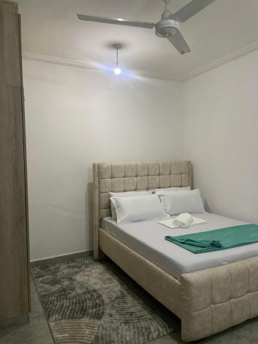 a bedroom with a bed with a ceiling fan at Bliss Residence Bamburi Mwembeni in Mombasa