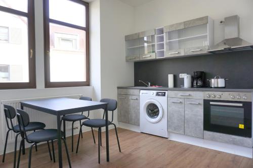 a kitchen with a table and a washing machine at 11 Monteursapartments zur Alleinnutzung in Klingenberg am Main