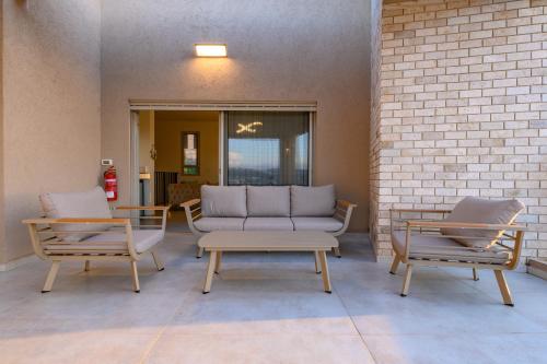a patio with two chairs and a couch and a table at וילה לוזאן - Lausanne Villa in Dāliyat el Karmil