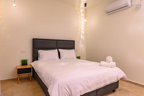 a bedroom with a large bed with white sheets at וילה לוזאן - Lausanne Villa in Dāliyat el Karmil