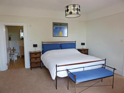 une chambre avec un grand lit avec des draps bleus et blancs dans l'établissement Broadstairs House Boutique B&B By The Sea, à Broadstairs