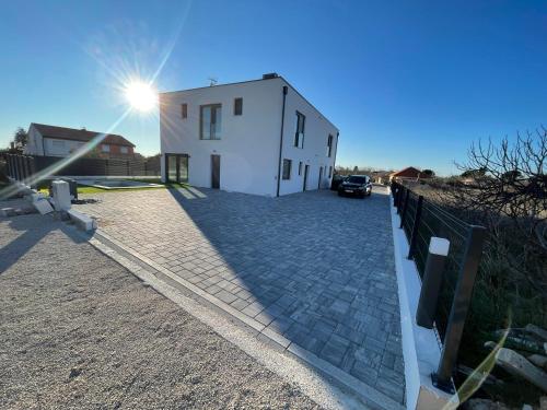 a white building with the sun in the sky at Villa T in Privlaka