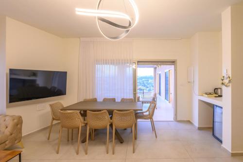 a dining room with a table and chairs at וילה לוזאן - Lausanne Villa in Dāliyat el Karmil