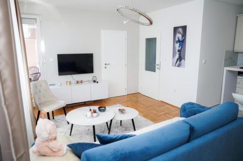 a living room with a blue couch and a table at Apartman Iskra in Bijeljina