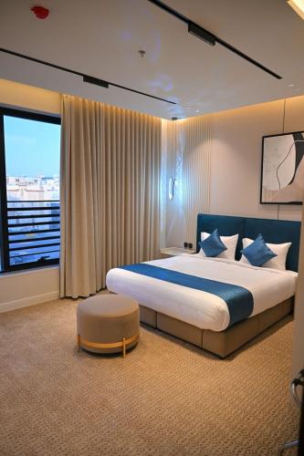 a bedroom with a large bed and a large window at جوهرة العليا للشقق المخدومة in Tabuk