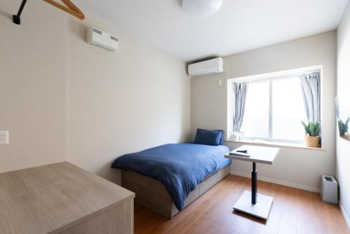 尾道市にあるHOTEL PG -2- - Vacation STAY 38330vのベッドと机と窓のある寝室