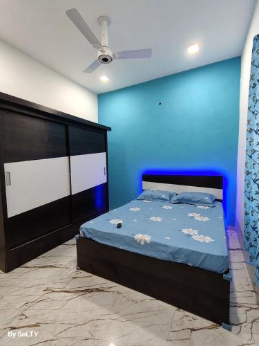 a bedroom with a bed and a blue wall at Yogratna Classic in Pune