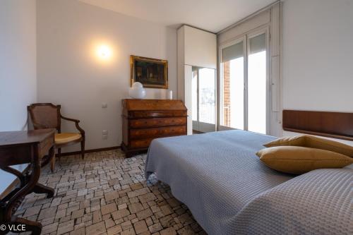 1 dormitorio con cama, escritorio y tocador en Villa Lucy - Porzione di villa con giardino, en Varenna
