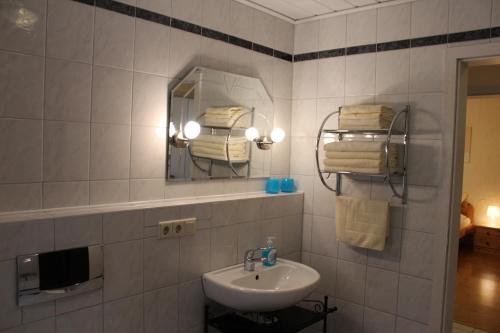 a bathroom with a sink and a mirror and towels at Gästehaus Kril in Rust