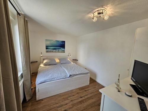 a bedroom with a bed and a desk with a television at Raphael - "Frank Sinatra" in Timmendorfer Strand