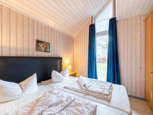 a bedroom with two beds and a window at Ferienhaus im Ferienpark Mirow in Granzow