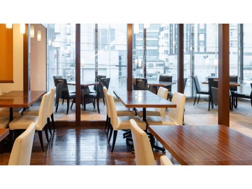 a restaurant with wooden tables and chairs and windows at The OneFive Sendai - Vacation STAY 45028v in Sendai