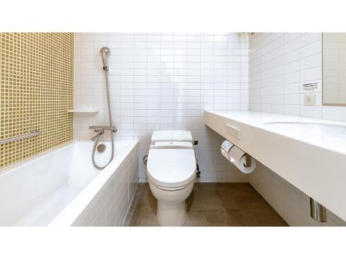 a bathroom with a toilet and a tub and a sink at The OneFive Sendai - Vacation STAY 45028v in Sendai