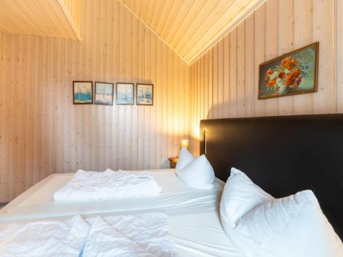 a bedroom with two white beds and a wooden wall at Ferienhaus mit privater Sauna in Granzow