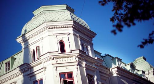 a white building with a green roof at Home Hotel Victoria in Jönköping