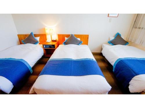 伊勢市にあるHotel Area One Ise Inter - Vacation STAY 38393vのベッド3台(青と白のシーツ付)が備わる客室です。
