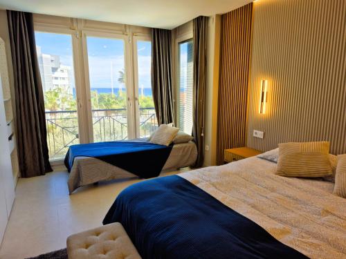 Una habitación de hotel con dos camas y balcón. en Villa Dorada Beach Alicante, en Alicante
