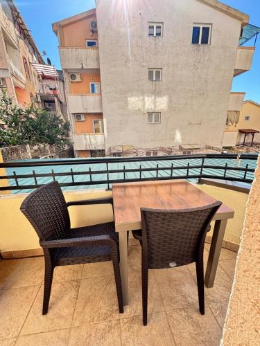 a table and chairs on a balcony with a building at Montetolgay in Becici