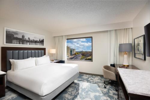 a hotel room with a bed and a desk and a window at DoubleTree by Hilton Houston Medical Center Hotel & Suites in Houston
