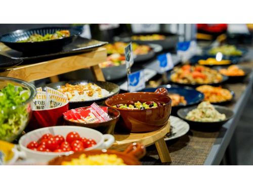 a buffet with plates of food and bowls of food at Hotel Area One Ise Inter - Vacation STAY 38519v in Ise