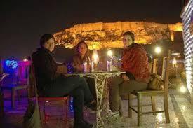a group of people sitting at a table at night at The Blue House in Jodhpur