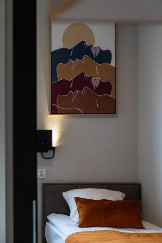 a bedroom with a bed with a painting on the wall at Hotel Kozerki in Kozerki
