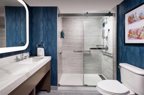 a bathroom with a shower with a toilet and a sink at DoubleTree by Hilton Houston Medical Center Hotel & Suites in Houston