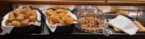 three baskets of different types of food on a counter at Hotel Mondschein in Sesto