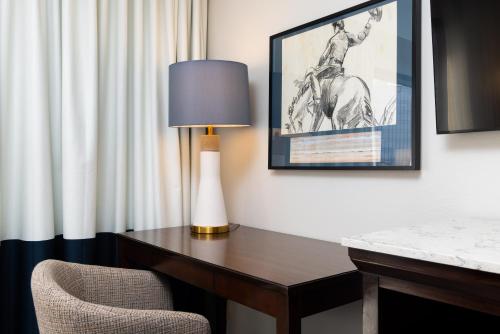 a desk with a lamp and a chair in a room at DoubleTree by Hilton Houston Medical Center Hotel & Suites in Houston