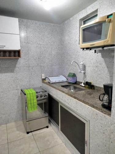 a kitchen with a sink and a stove and a microwave at Apto com Garagem - PENHA in Rio de Janeiro
