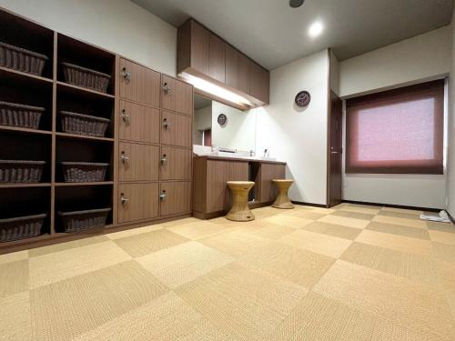 a large room with wooden cabinets and a desk in it at Second Inn Hana Hotel Hanazono Inter - Vacation STAY 40274v in Fukaya