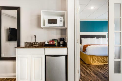 a hotel room with a bed and a kitchen with a sink at Riverwalk Plaza Hotel in San Antonio
