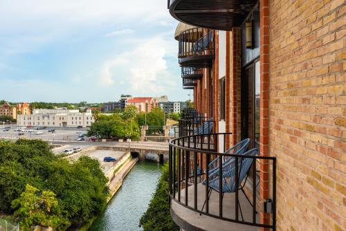 a balcony of a building with a view of a river at Riverwalk Plaza Hotel in San Antonio