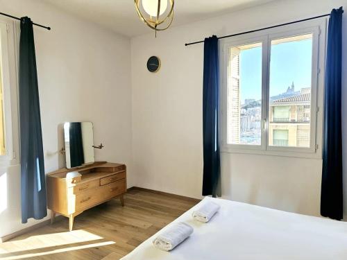 une chambre avec un lit, une télévision et une fenêtre dans l'établissement Seduisant 3 chambres avec vue sur le Vieux-Port et proche du Panier, à Marseille