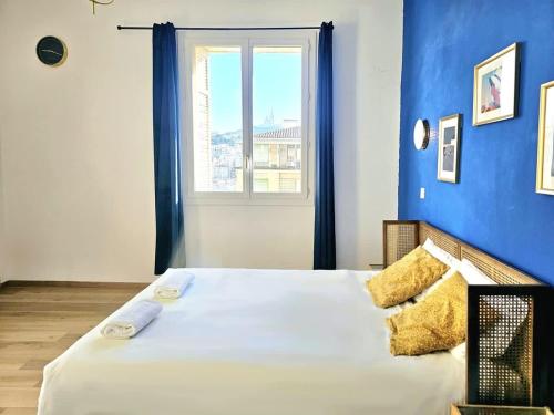 une chambre avec un grand lit avec un mur bleu dans l'établissement Seduisant 3 chambres avec vue sur le Vieux-Port et proche du Panier, à Marseille
