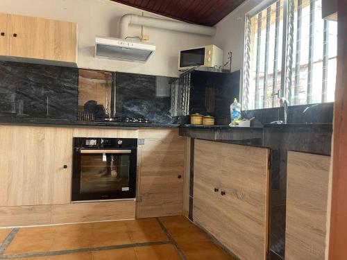 a kitchen with wooden cabinets and a stove top oven at Maison spiritaine in Saint Esprit